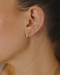 Woman Wearing Gold Birth Flower Stud Earrings