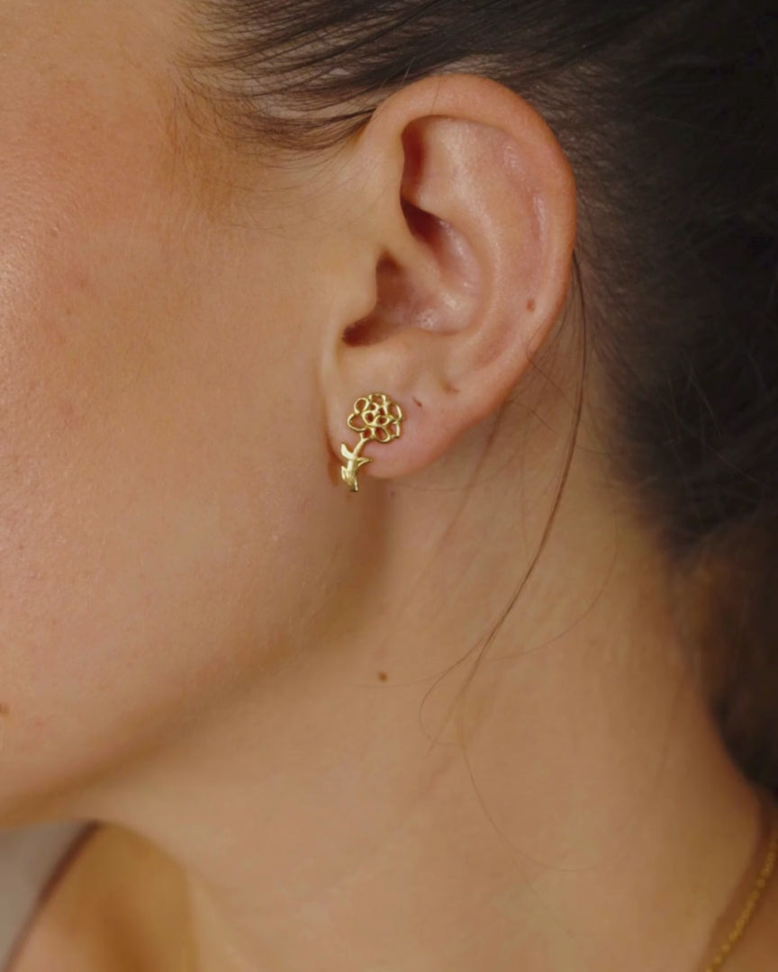Woman Wearing Gold Birth Flower Stud Earrings